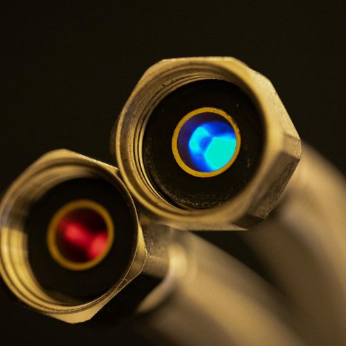 Detailed shot of optical lenses reflecting blue and red light, showcasing precision technology.